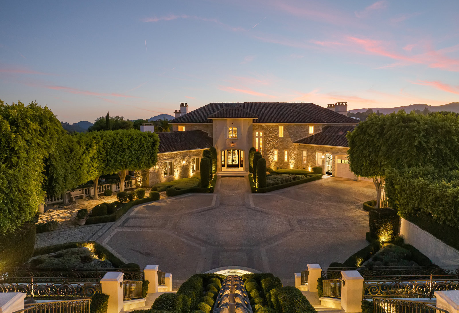 Motor court arrival framed by formal landscaping